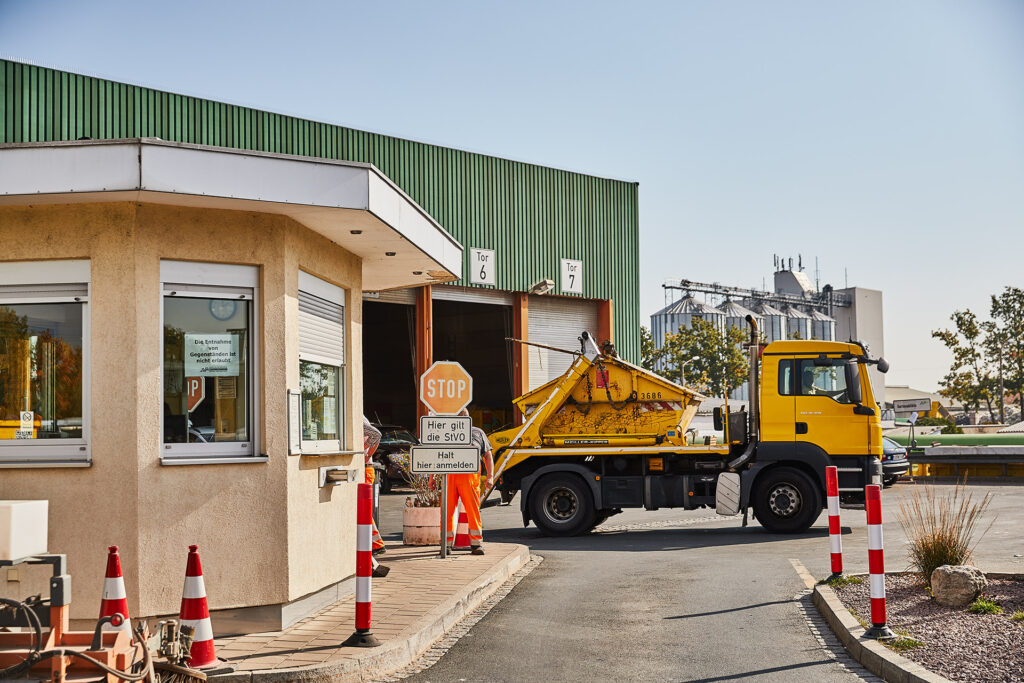 Ein gelber Lastwagen steht vor dem Gebäude der Umladestation.
