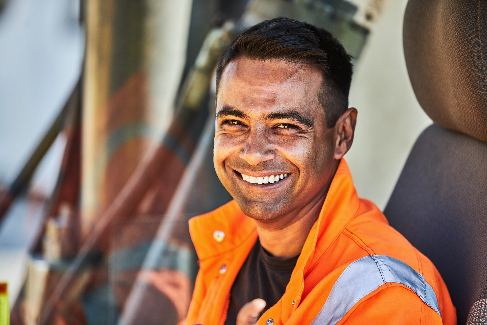 Portraitfoto von Arton Kadrija. Er trägt eine orange Warnjacke und lächelt. (&copy; )